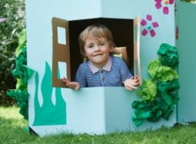 child in cardboard house