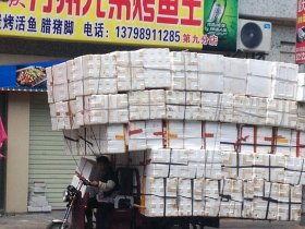 Cutting transport costs? A woman in China loaded her tricycle with hundreds of cardboard boxes