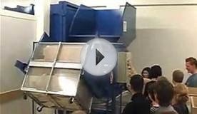 Girl lifting cardboard boxes into an auger crusher compactor