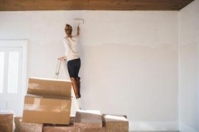 Young woman decorating new home - Cultura/Hugh Whitaker/Riser/Getty Images